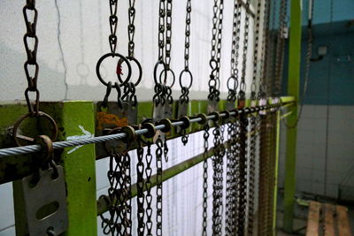Padlocks on metal fence against building
