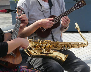 Midsection of man playing guitar