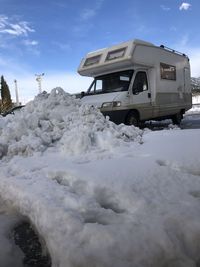 Snow covered car against sky