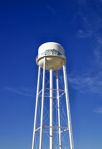 Low angle view of water tower against blue sky