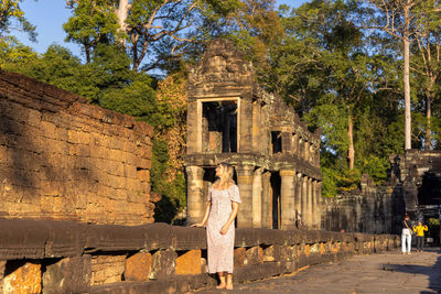 Rear view of woman standing by old ruins