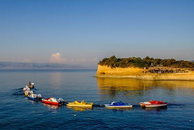 Boats in sea against blue sky