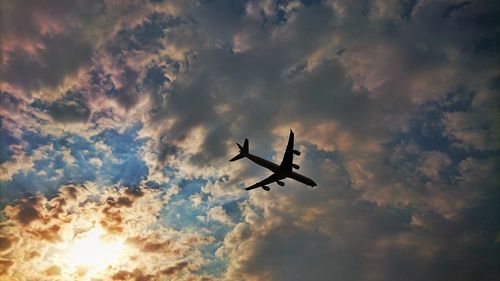 Low angle view of silhouette airplane against sky during sunset