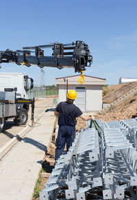 Rear view of worker at construction site during sunny day