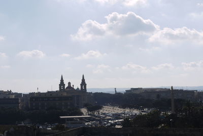 View of cityscape against cloudy sky