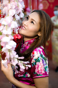 Portrait of smiling woman with pink flower