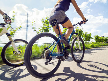 Low section of man riding bicycle on road