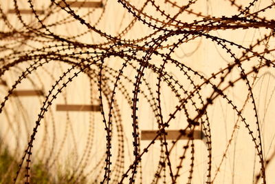 Close-up of barbed wire fence against sky