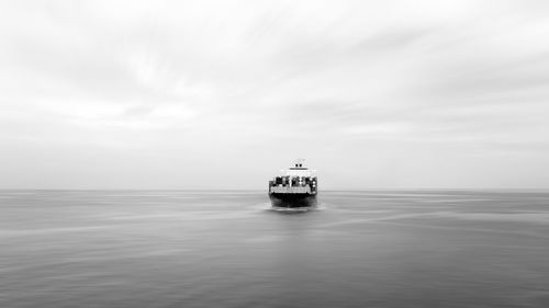 Black and white container ship sailing in deep sea for transporting cargo logistic import and export 