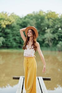 Portrait of young woman wearing hat standing outdoors