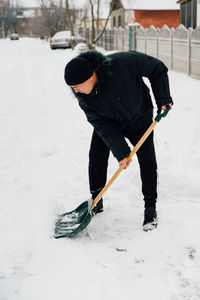 Snow collapse. senior man cleaning snow at winter weather with a shovel