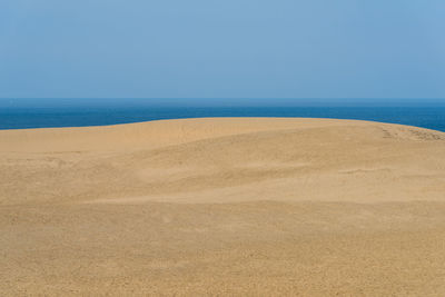 Scenic view of beach against clear blue sky