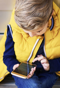 Rear view of boy holding book