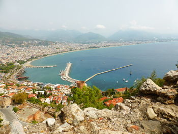 High angle view of sea and cityscape against sky