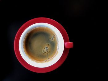 Directly above shot of coffee on table against black background