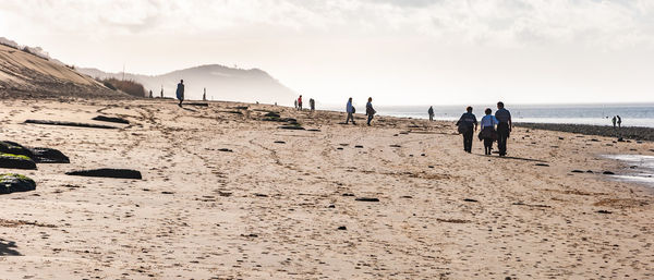 People on beach against sky