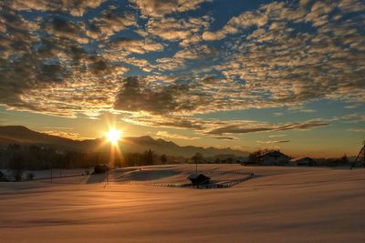 Scenic view of snowcapped landscape against sky during sunset