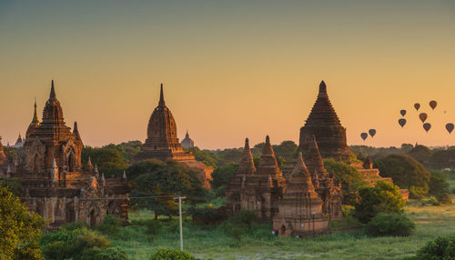 Panoramic view of temple and building against sky during sunset