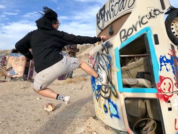 Side view of boy skateboarding on bus