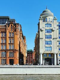 Buildings against clear blue sky in city