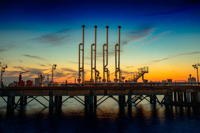 Pier over sea against sky at sunset