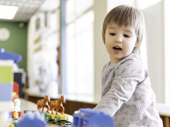 Toddler plays with toy blocks. little boy stares on toy constructor. kindergarten or nursery. 