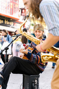 Woman playing guitar in city