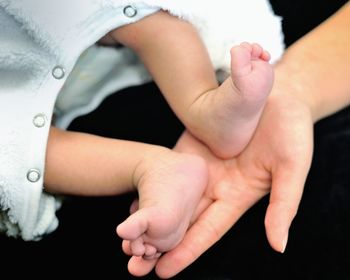 Close-up of hands touching baby feet