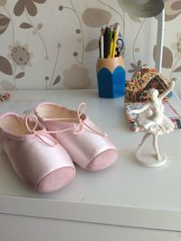 High angle view of ballet shoe and figurine on table