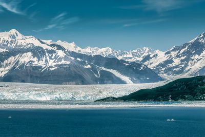 Scenic view of snowcapped mountains against blue sky