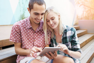 Happy couple looking at digital tablet