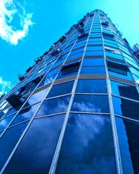 Low angle view of glass building against sky