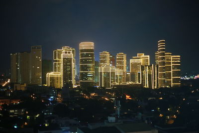 Illuminated modern buildings against clear sky at night