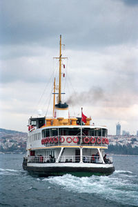 Ferry in sea against city