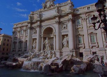 Statues in front of historic building against sky