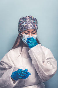 Doctor wearing mask against blue background