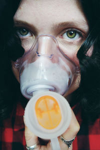 Close-up portrait of mid adult woman wearing gas mask