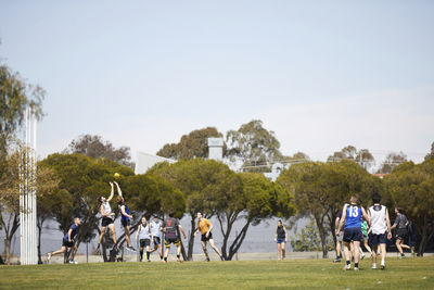 People playing soccer against sky