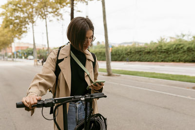 Young woman riding bicycle on road