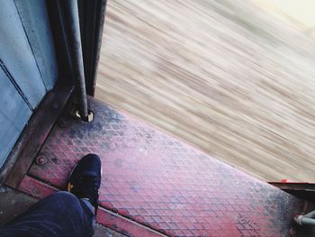 Low section of man standing in train