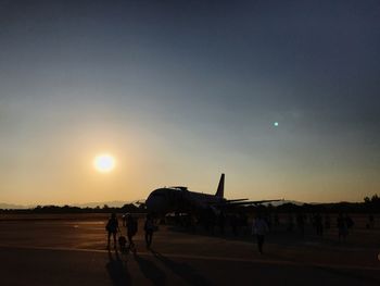 People on road against sky during sunset