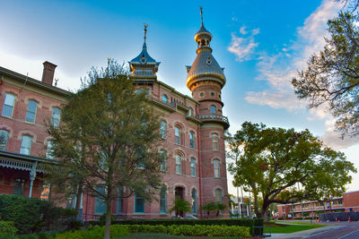 Low angle view of trees and buildings against sky