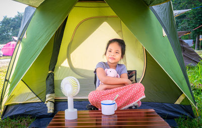 Smiling girl sitting in tent