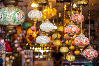 Illuminated lanterns hanging at market stall