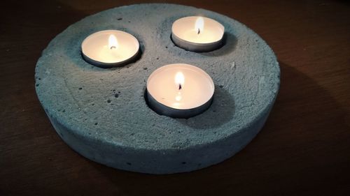 High angle view of illuminated candle on table
