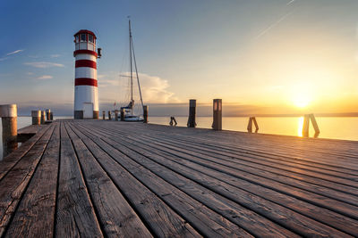 Pier over sea against sky during sunset