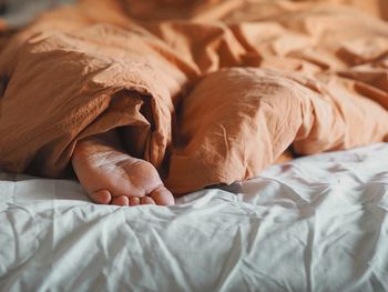 Close-up of baby sleeping on bed at home