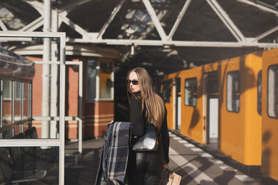 Portrait of young woman standing in train