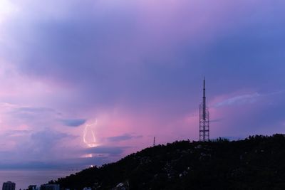 Low angle view of communications tower against sky at sunset