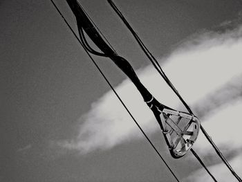 Low angle view of cables against cloudy sky